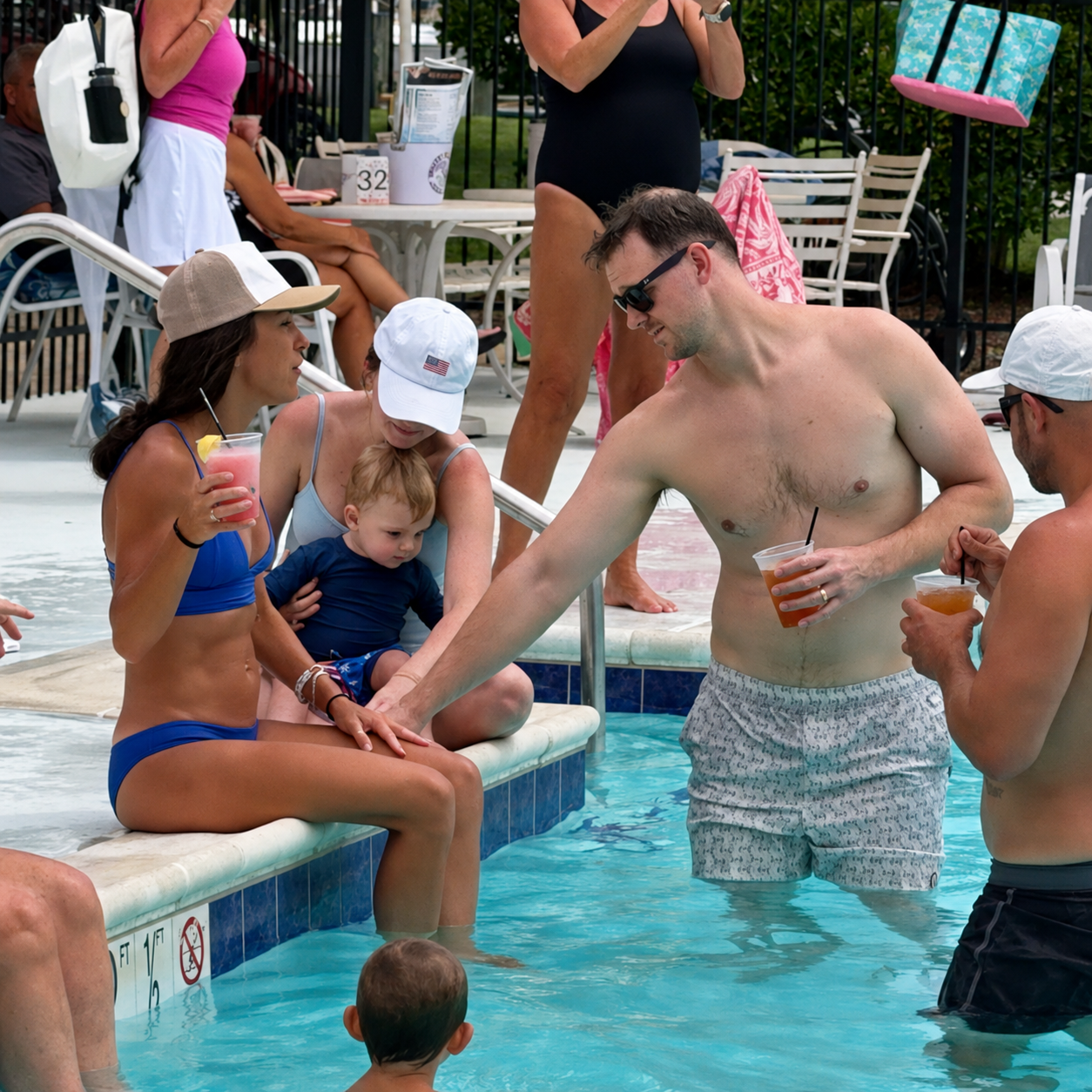Members gathered by the pool enjoying summer at the club